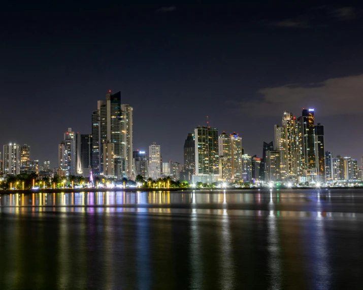 a large body of water near many buildings at night