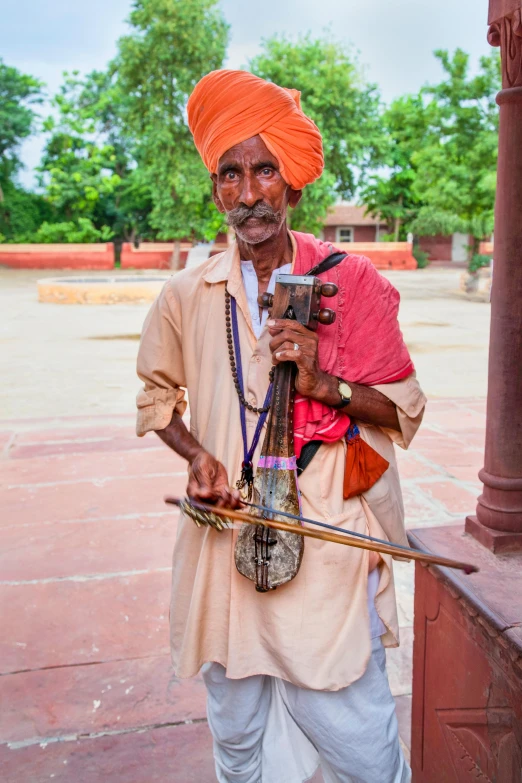 a man with a large stick and a small camera in his hands