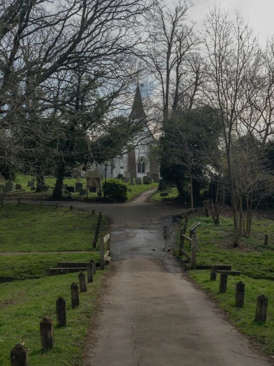 a rural road that leads to some houses in the background