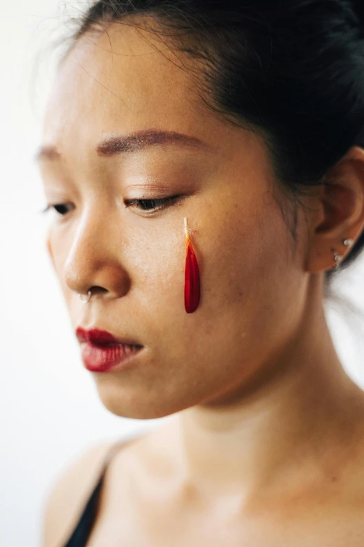 the woman is wearing earrings with red and yellow things