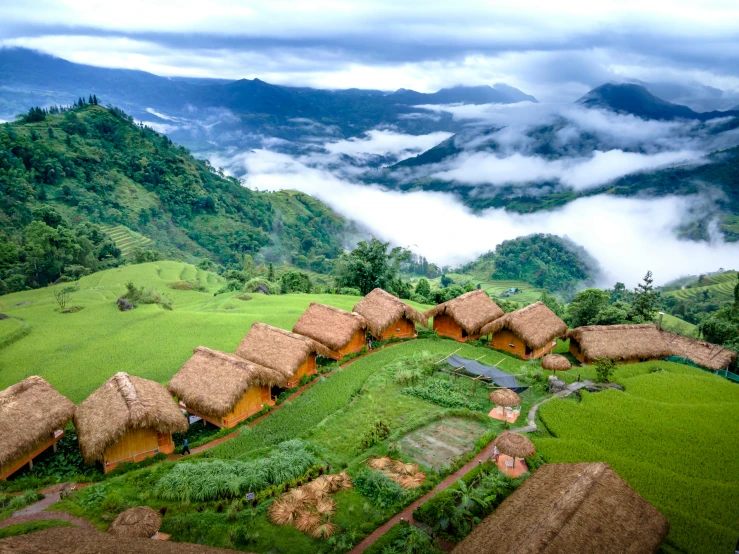 a small village with thatched roof in a valley