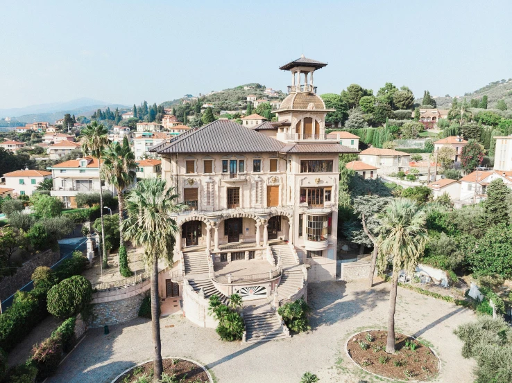 an aerial view of an old victorian home with palm trees and tall buildings