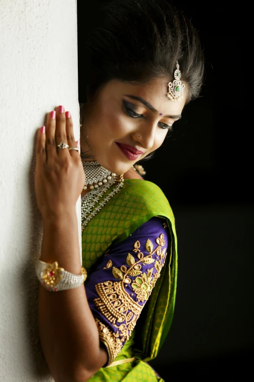 woman leaning on wall and holding onto her hands