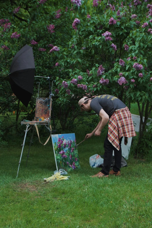 an older woman doing painting outside in the rain