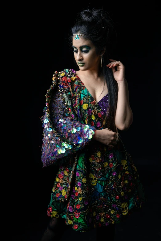 a woman with black makeup and bright clothes in a dark room