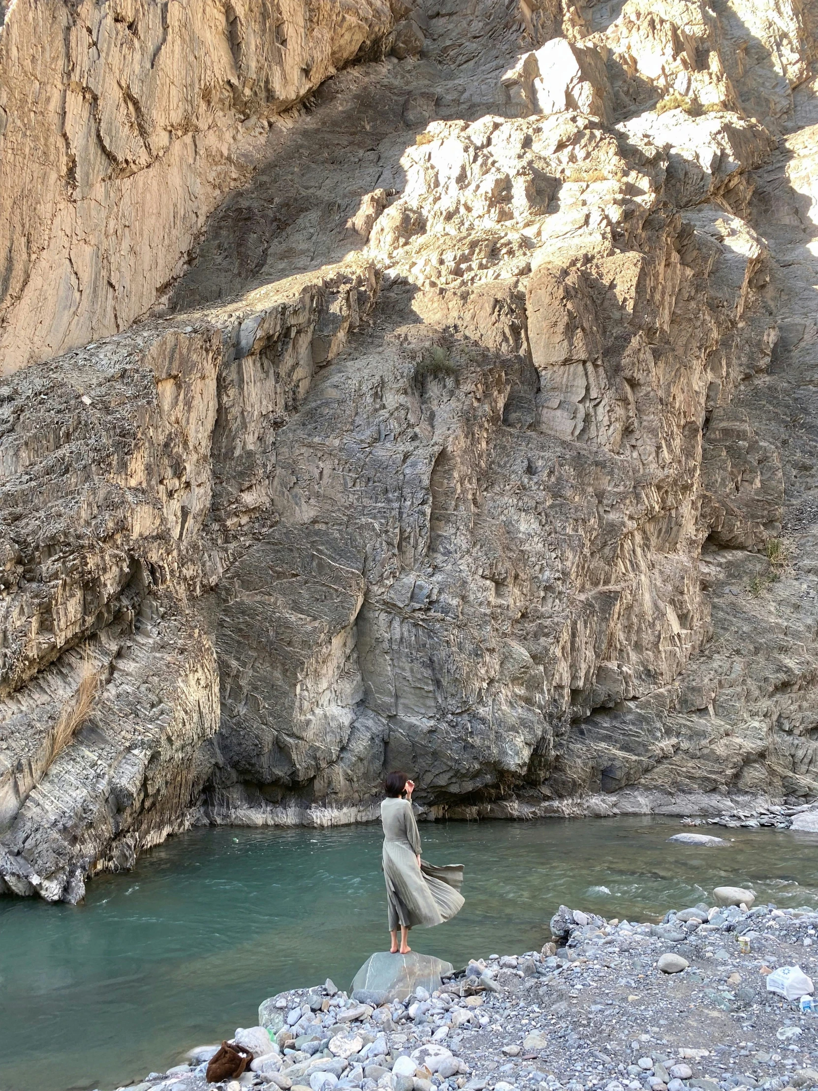 the man standing next to the water in the mountains