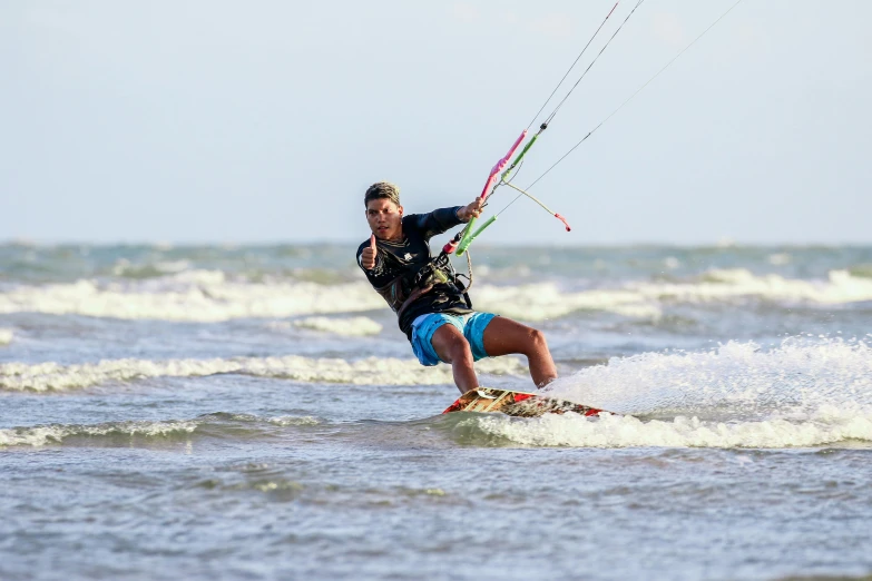 a man is on the water holding onto a para sail