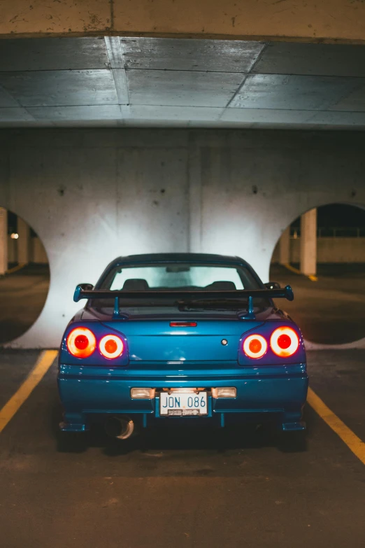 the back end of a blue sports car in a parking lot