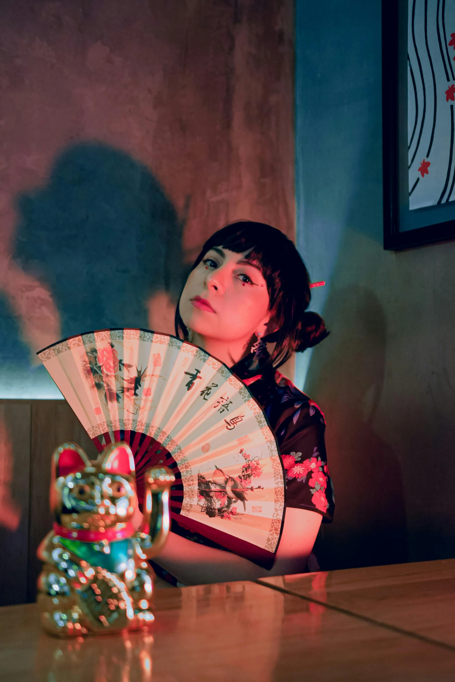 woman with red hair sitting on a chair with a fan