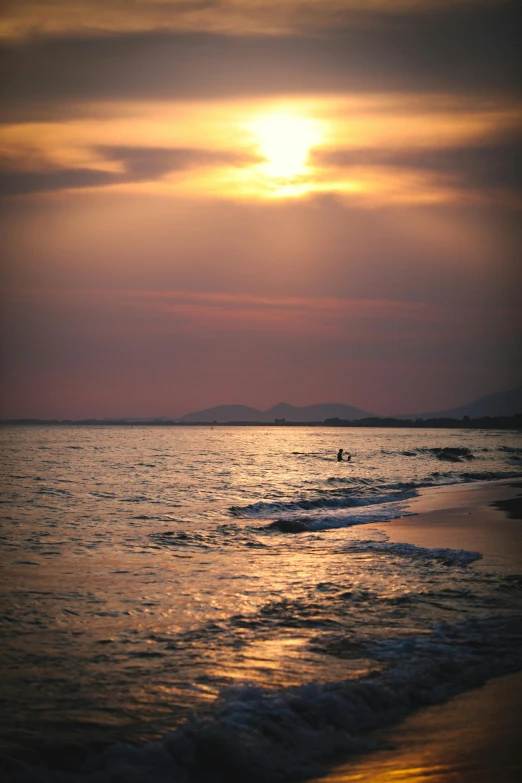 a couple of people walking across a beach