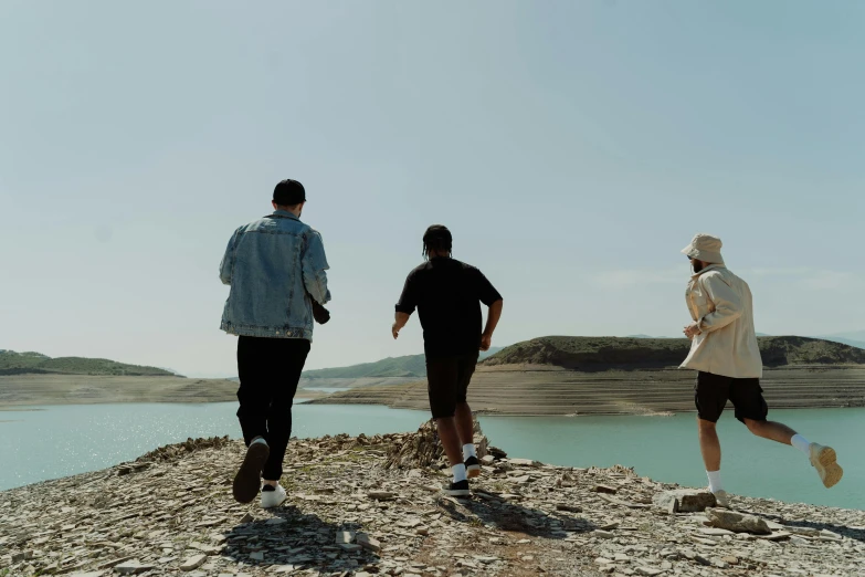 three guys are standing on top of a mountain