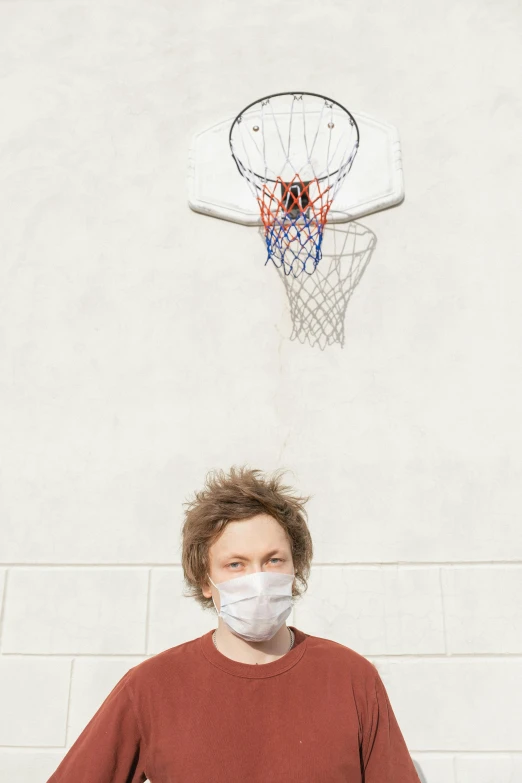 a person with a surgical mask and basketball net