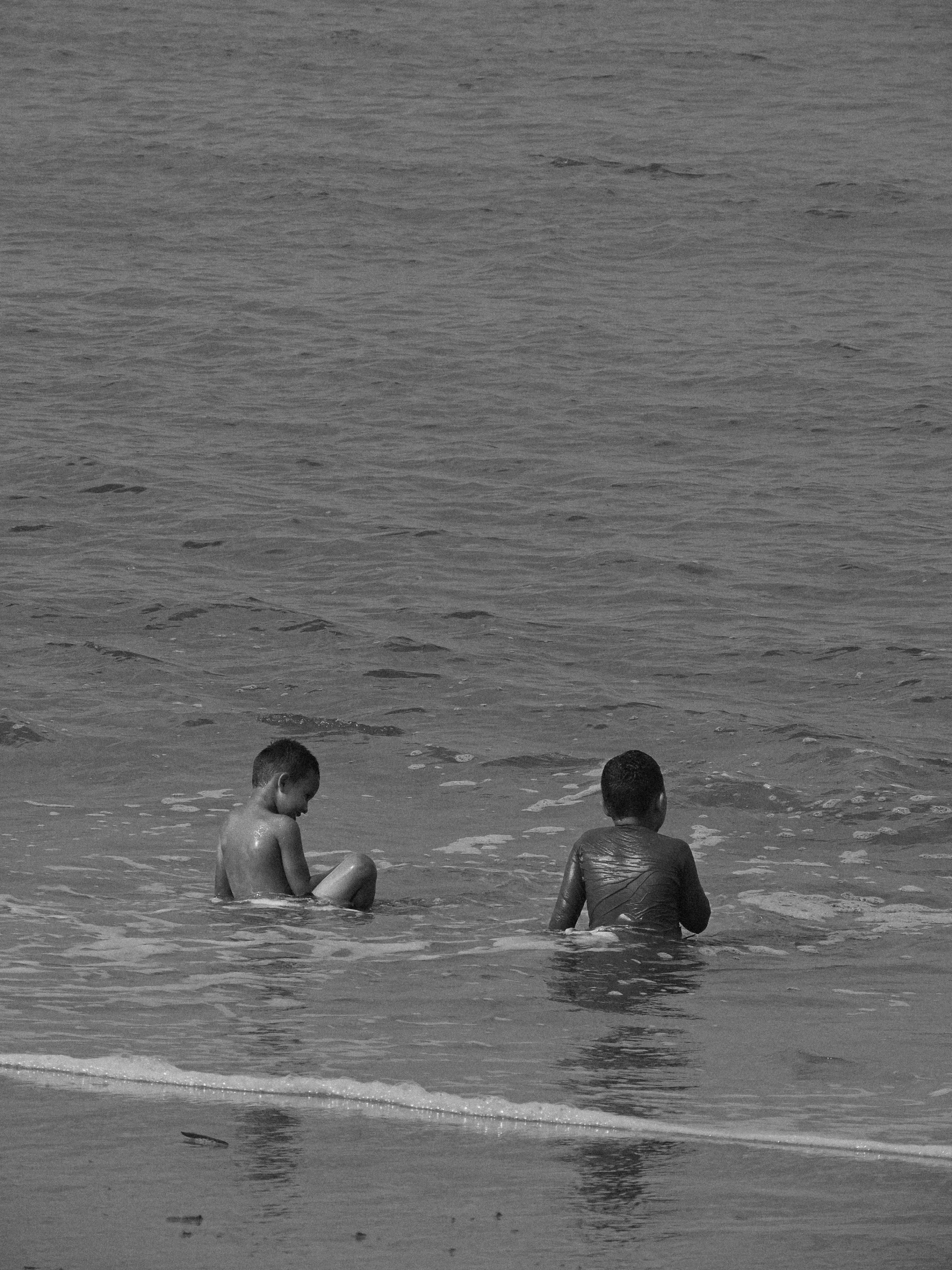 some people sitting on the beach in the water