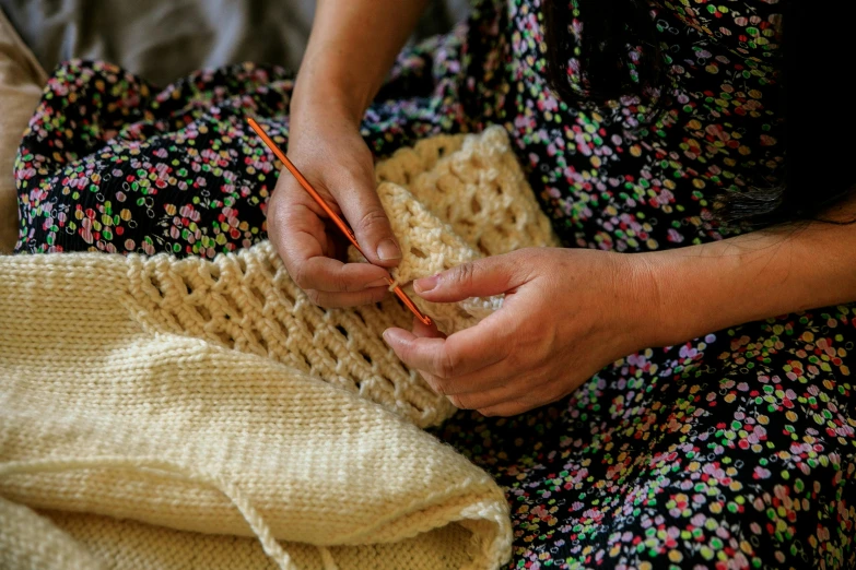 a woman wearing a dress holding a knitted piece