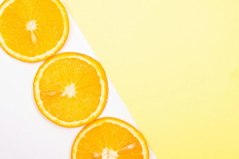 five sliced oranges on a white and gray surface