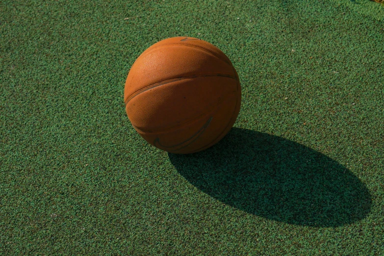 an orange basketball on top of a field