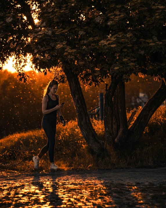 a person jogging down the road as the sun goes down