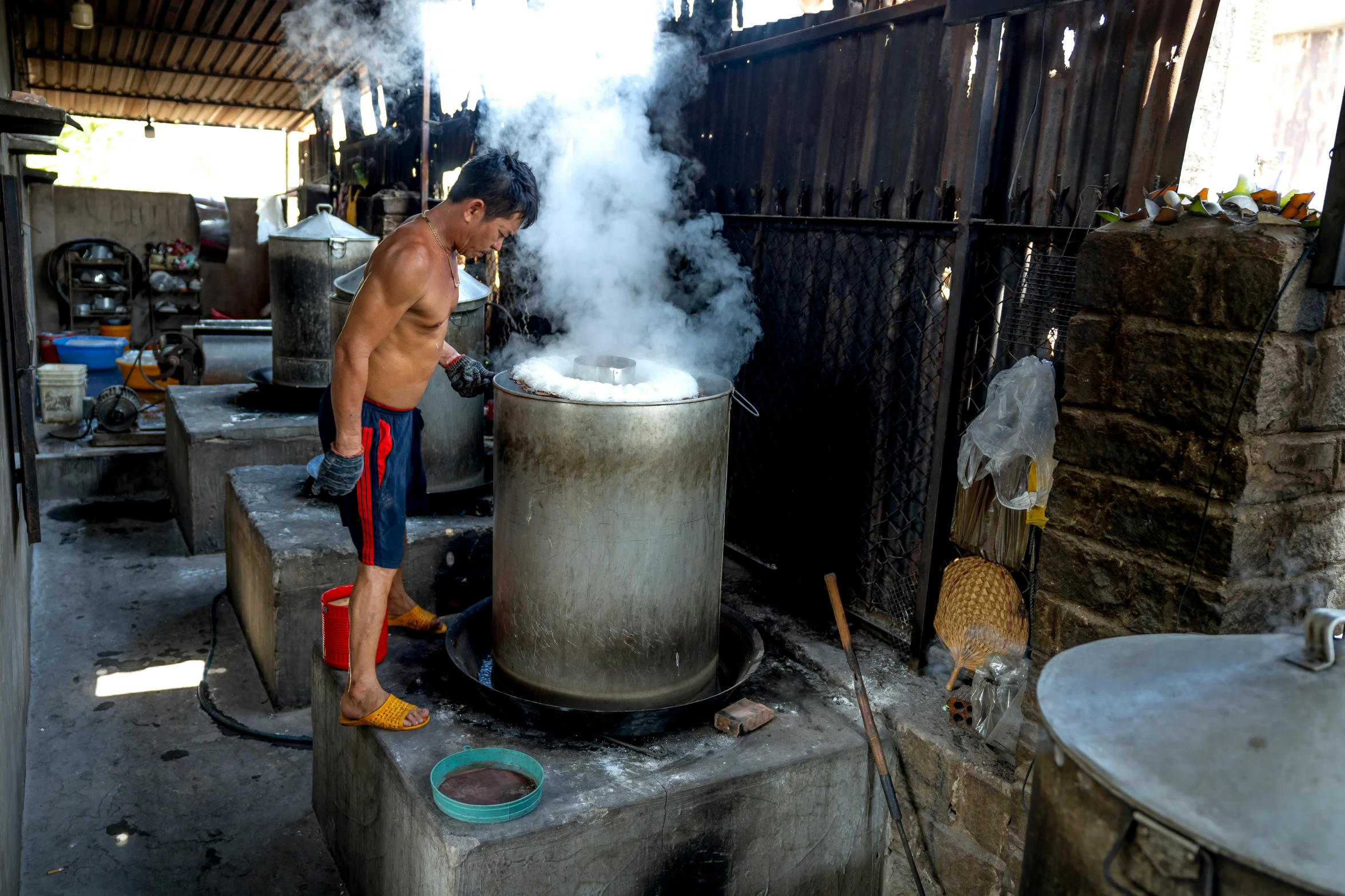 a shirtless man standing at an open pot