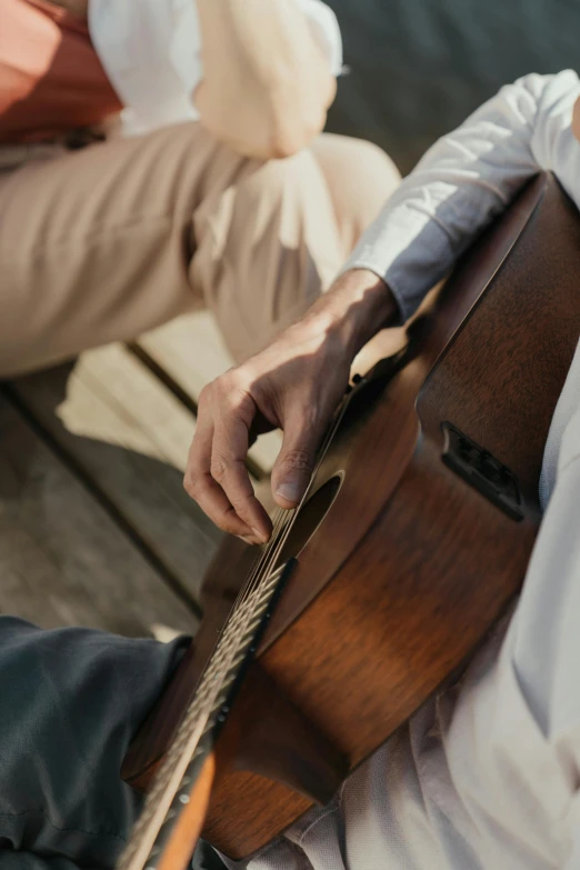 person with a guitar sitting by himself on a dock