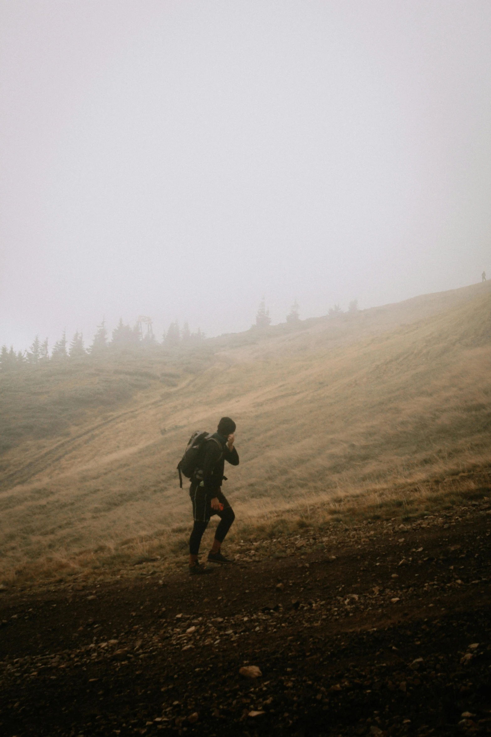 the man stands alone in a hilly field