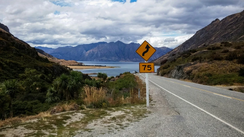 a street sign on the side of the road in a mountainous area