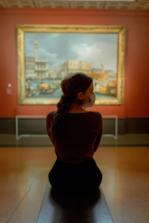 woman sitting on a floor in front of a painting