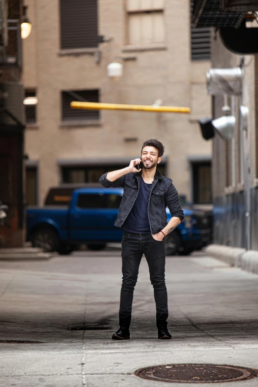 a young man is standing on the sidewalk