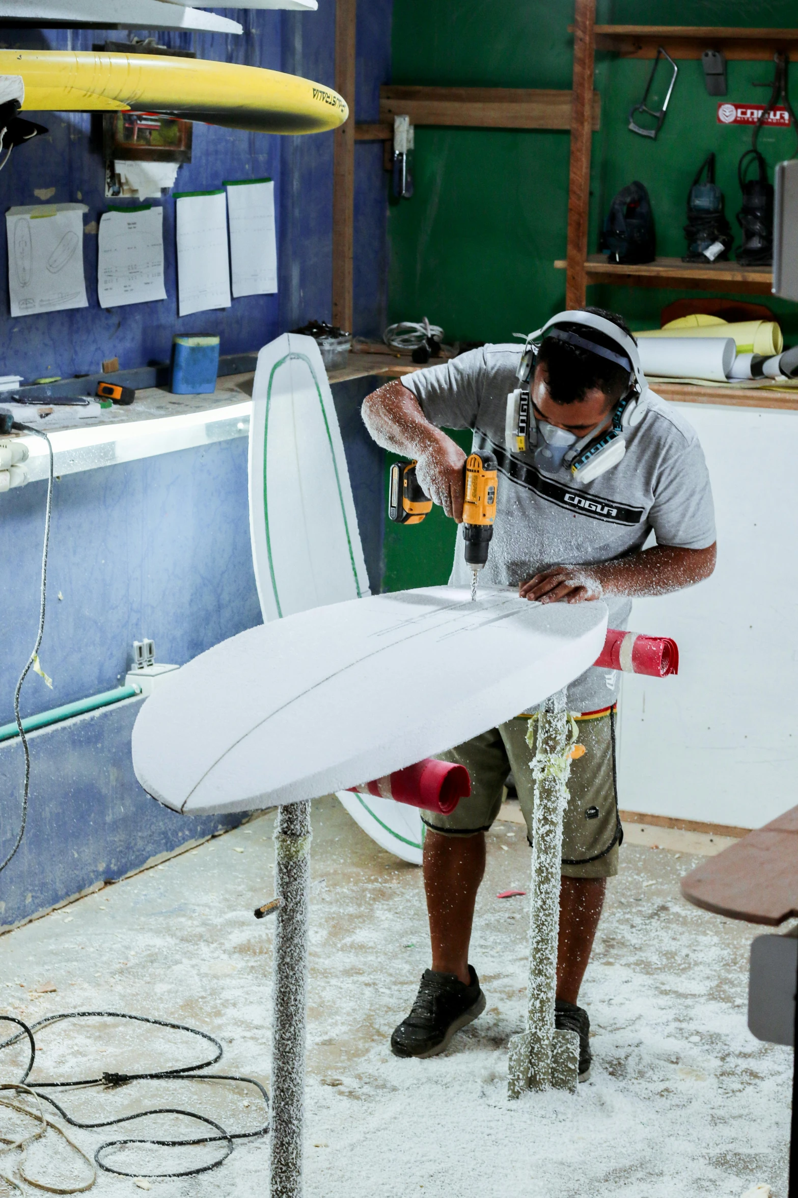 the man is working on some boards in his shop