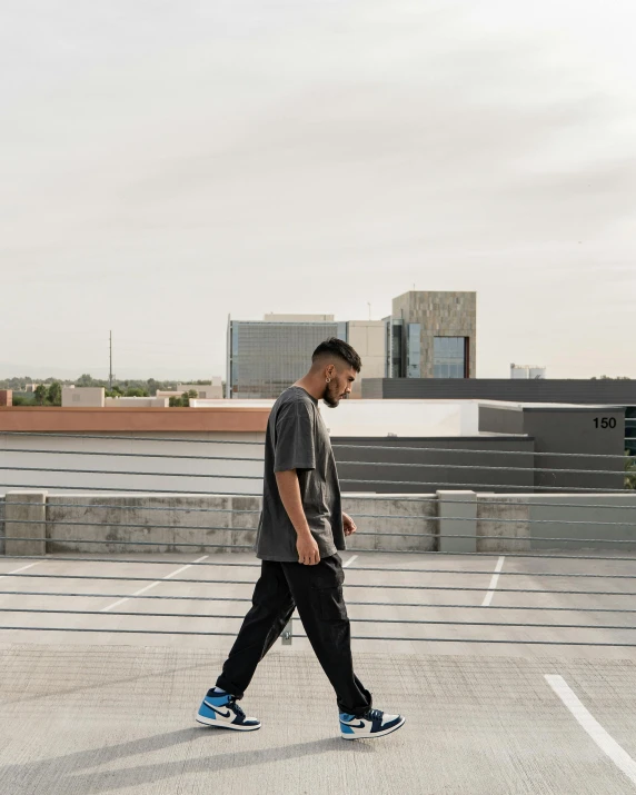 a man in black pants walking down the street