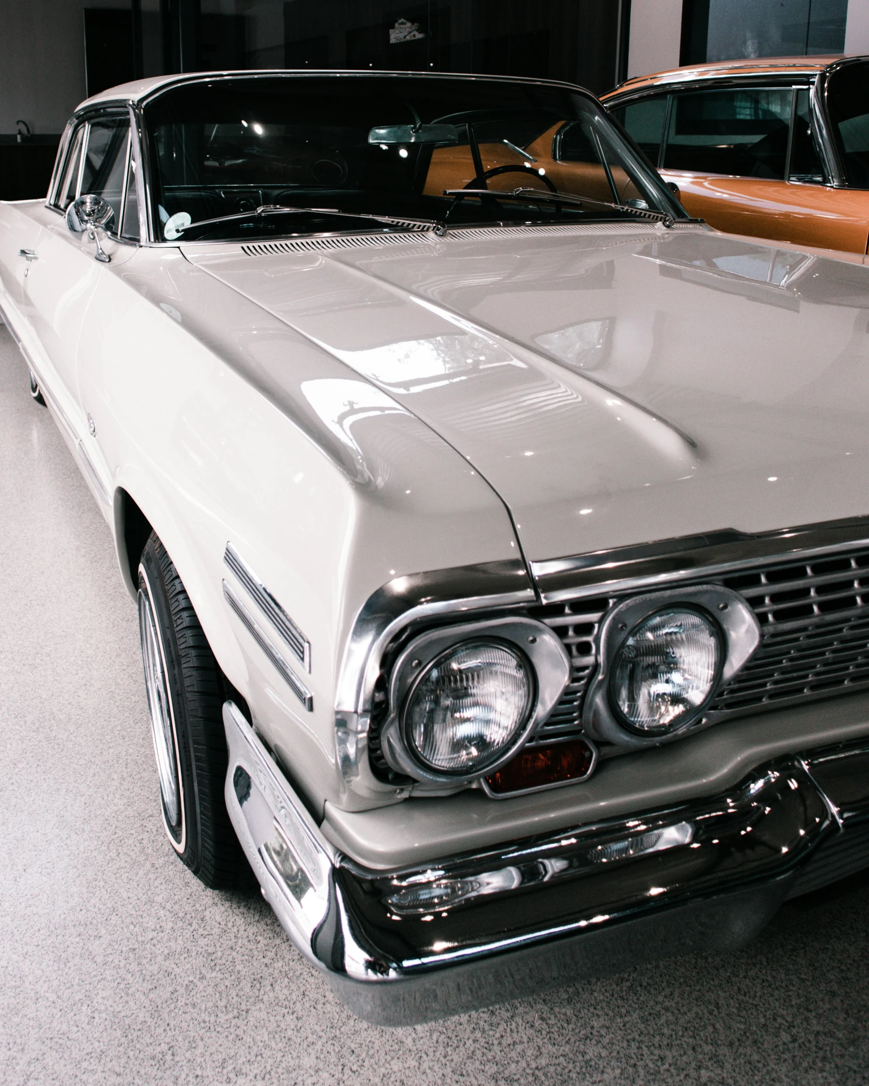 a car in a showroom near other classic cars