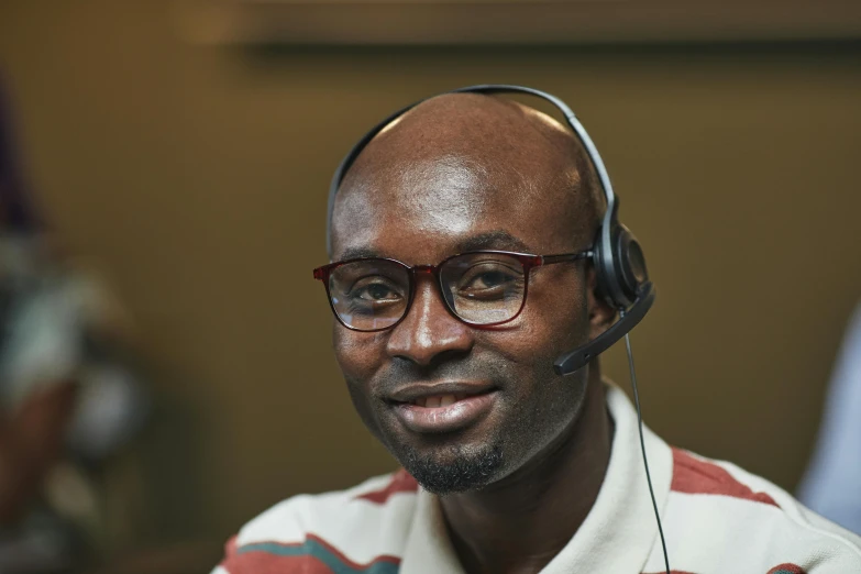 an african american man wearing headphones sitting at a desk