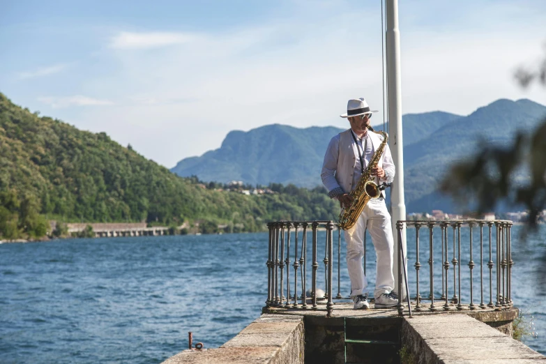 a man in a white suit and hat plays the saxophone