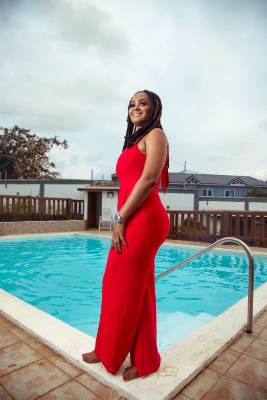 a black woman standing by a pool