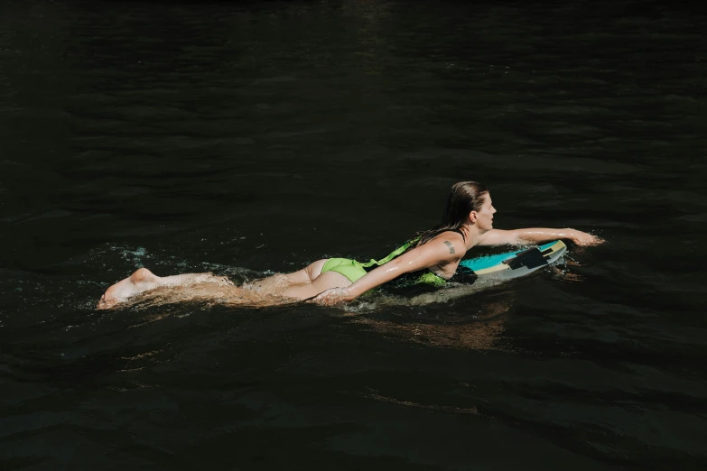 a man in a bikini lying on a small paddle board
