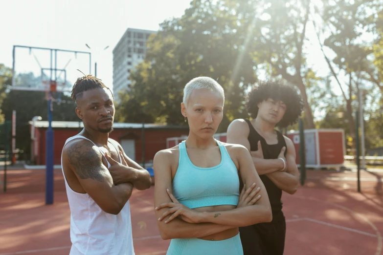 two women and one man standing on a tennis court