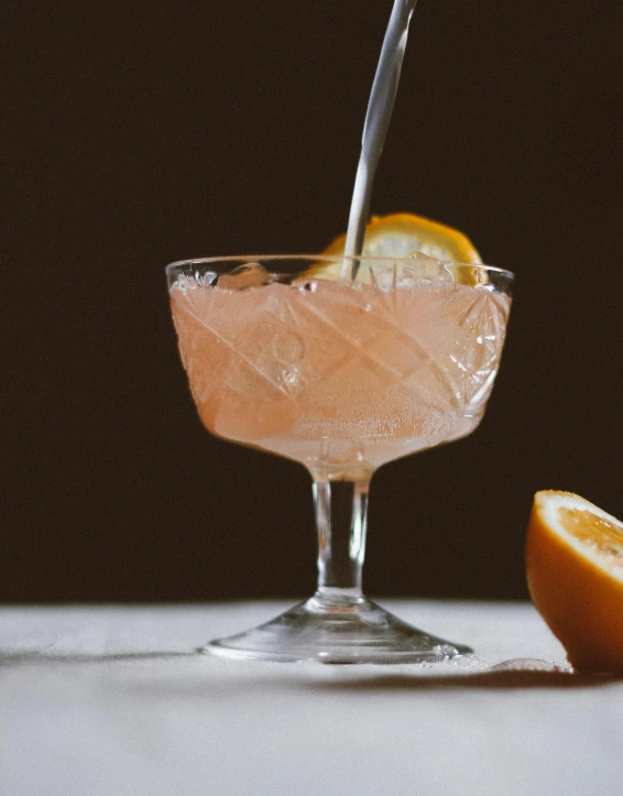 a drink being poured into a glass from a spoon