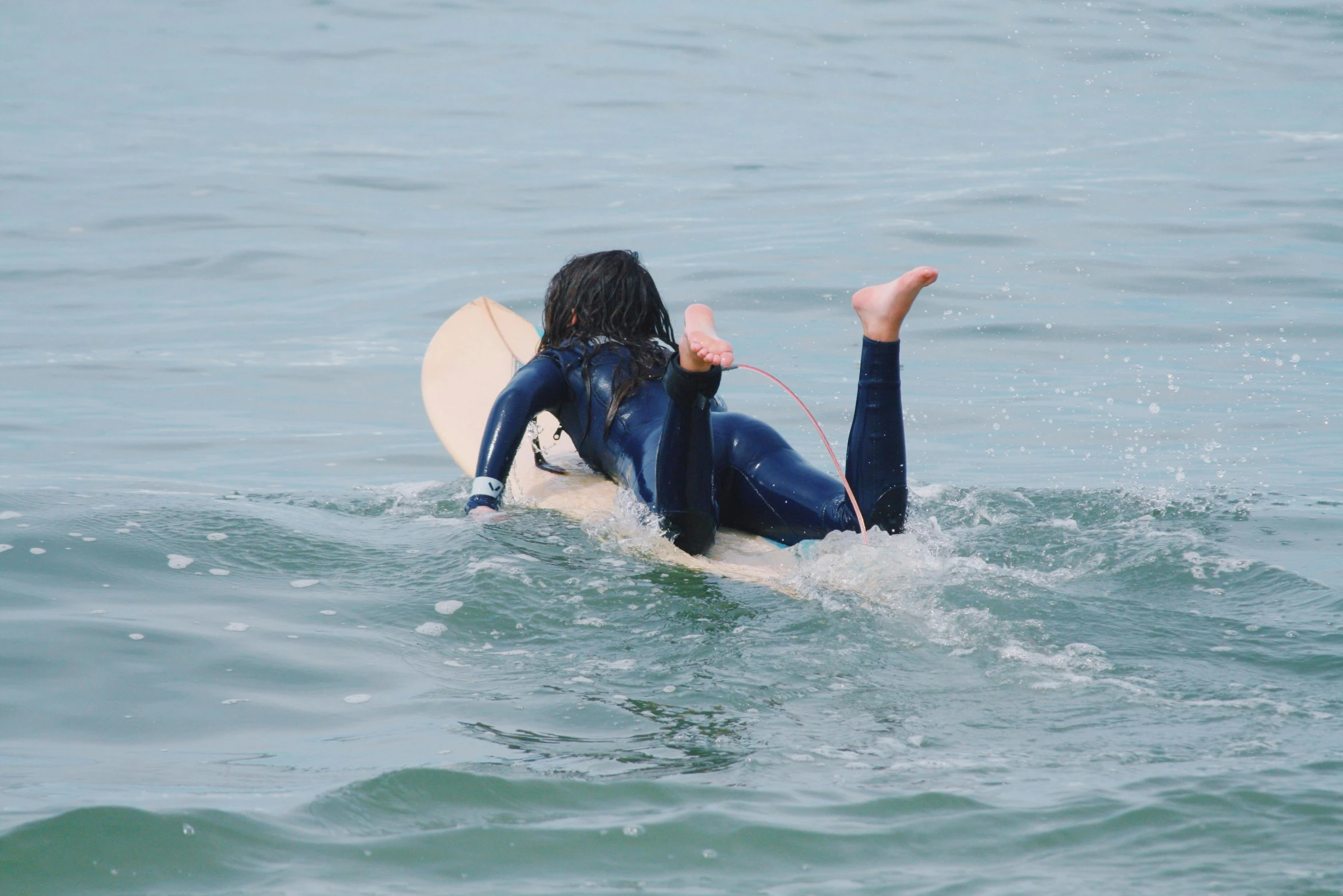 a woman riding a surfboard on top of water