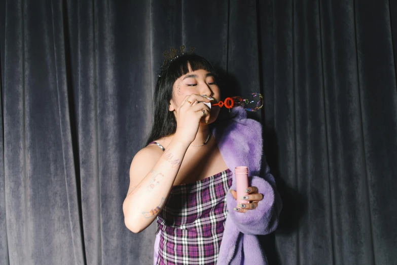 a woman blowing soap on her nose with one hand