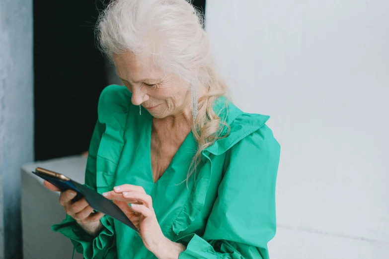 a person wearing a green dress using an electronic device