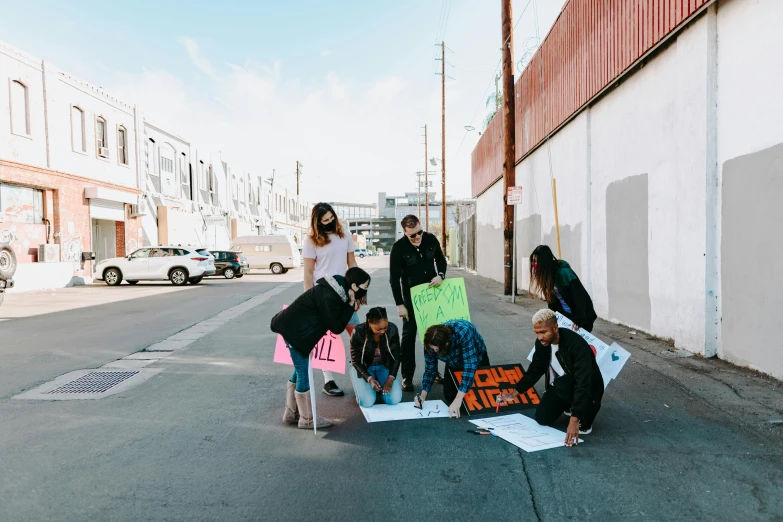 a group of people standing around each other on the street