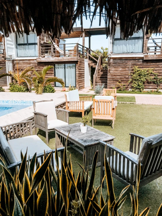 a small outdoor area with chairs and table near a pool