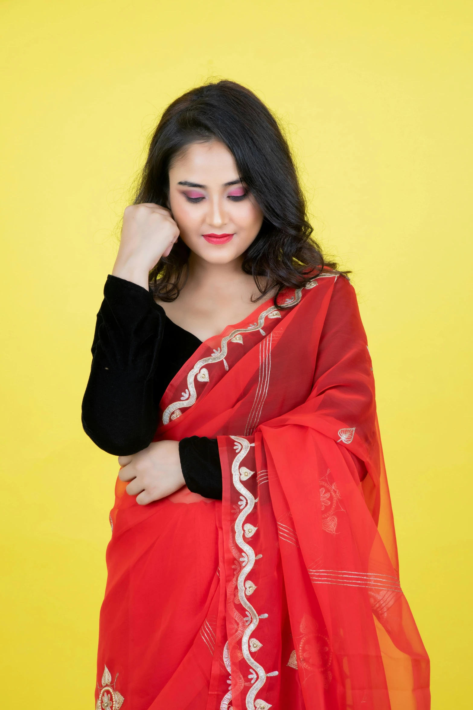 a woman posing in a red shawl on a yellow background