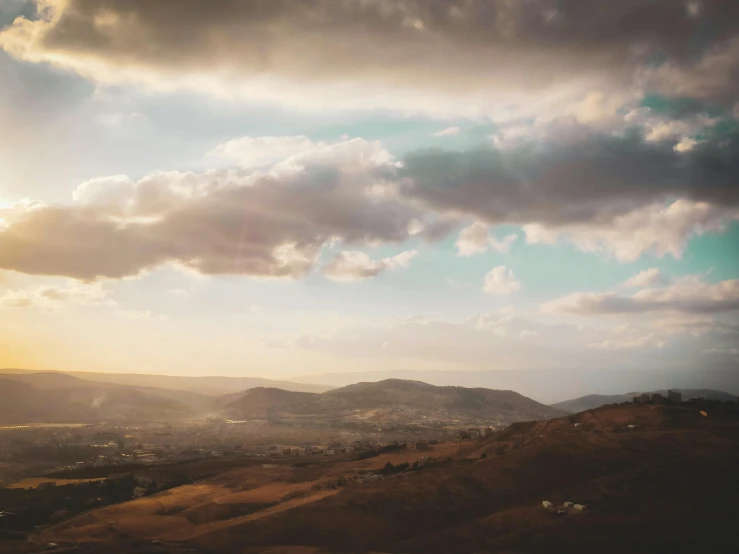 some clouds and a mountain and buildings in the distance