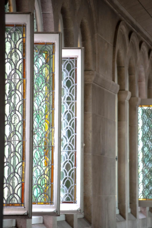 two glass windows in an ornate building with stone walls and arched pillars