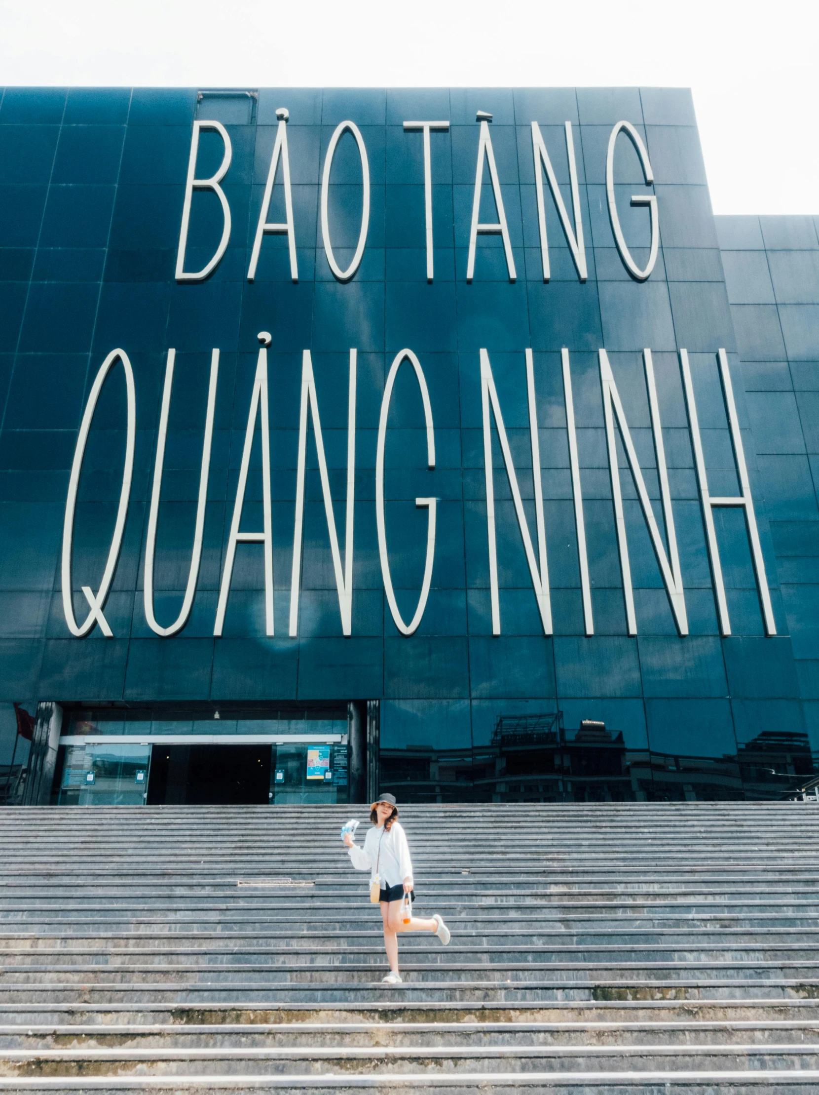 a young woman standing on a step of some steps