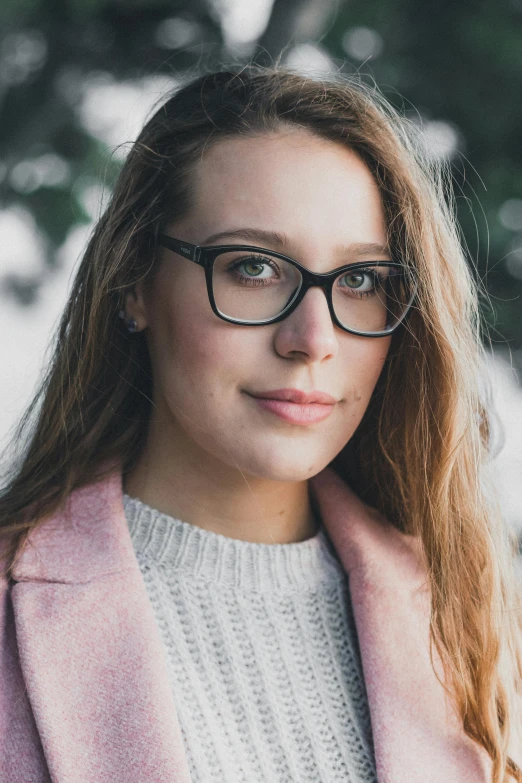 a woman wearing glasses and a pink coat