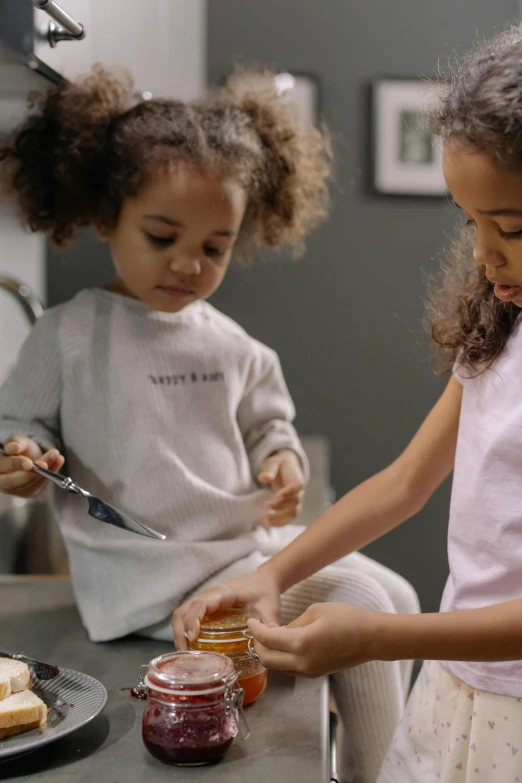 two s using a knife to cut into jam