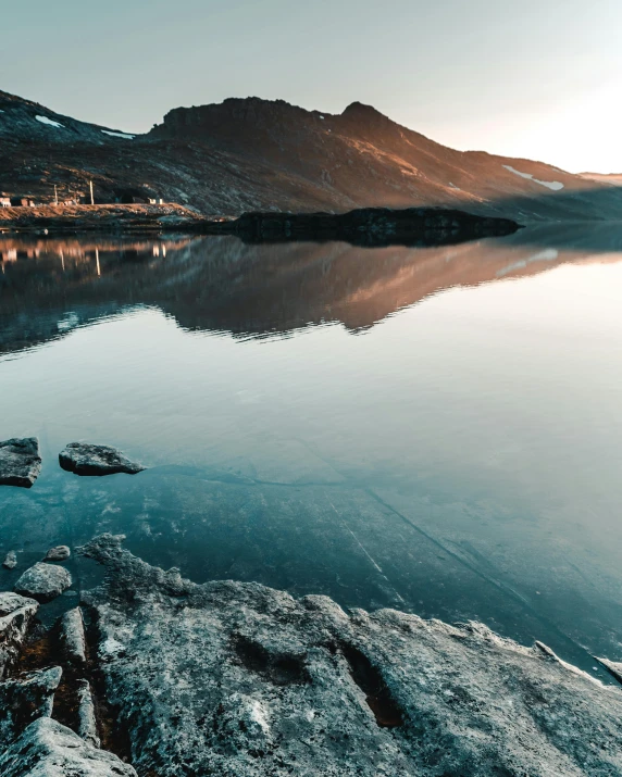 a mountain lake with trees and lights reflecting on the water