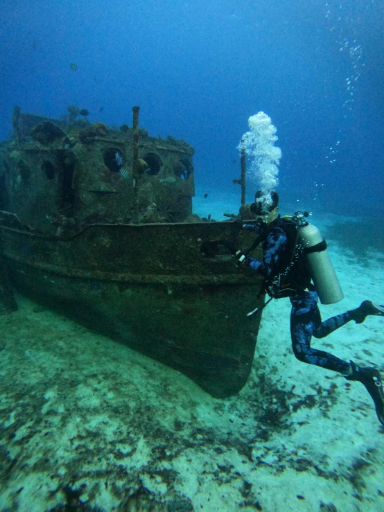 there is a scuba diving next to an abandoned boat