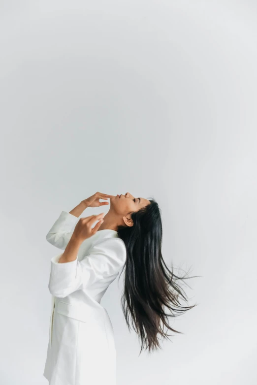 a woman standing on top of a white sheet holding a bottle